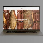 E-Commerce-Website von Tesone Alimentari auf einem Laptop mit Bildern von Wurstwaren